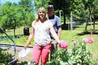 Sue and Robert Clinton in their backyard on Bedford Road. “The flowers are for the bees,” Sue said. Photo/Craig Bakay